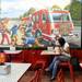 Myri McFarland, of Ann Arbor, sits in front of a large Wolverine themed mural at Firehouse Subs on Wednesday afternoon.  Melanie Maxwell I AnnArbor.com